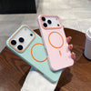 A pink phone case with orange circular designs is displayed next to a light blue version on a wooden table.