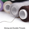 A close-up of various colored polyester sewing threads on spools, with a single strand extending from one spool.