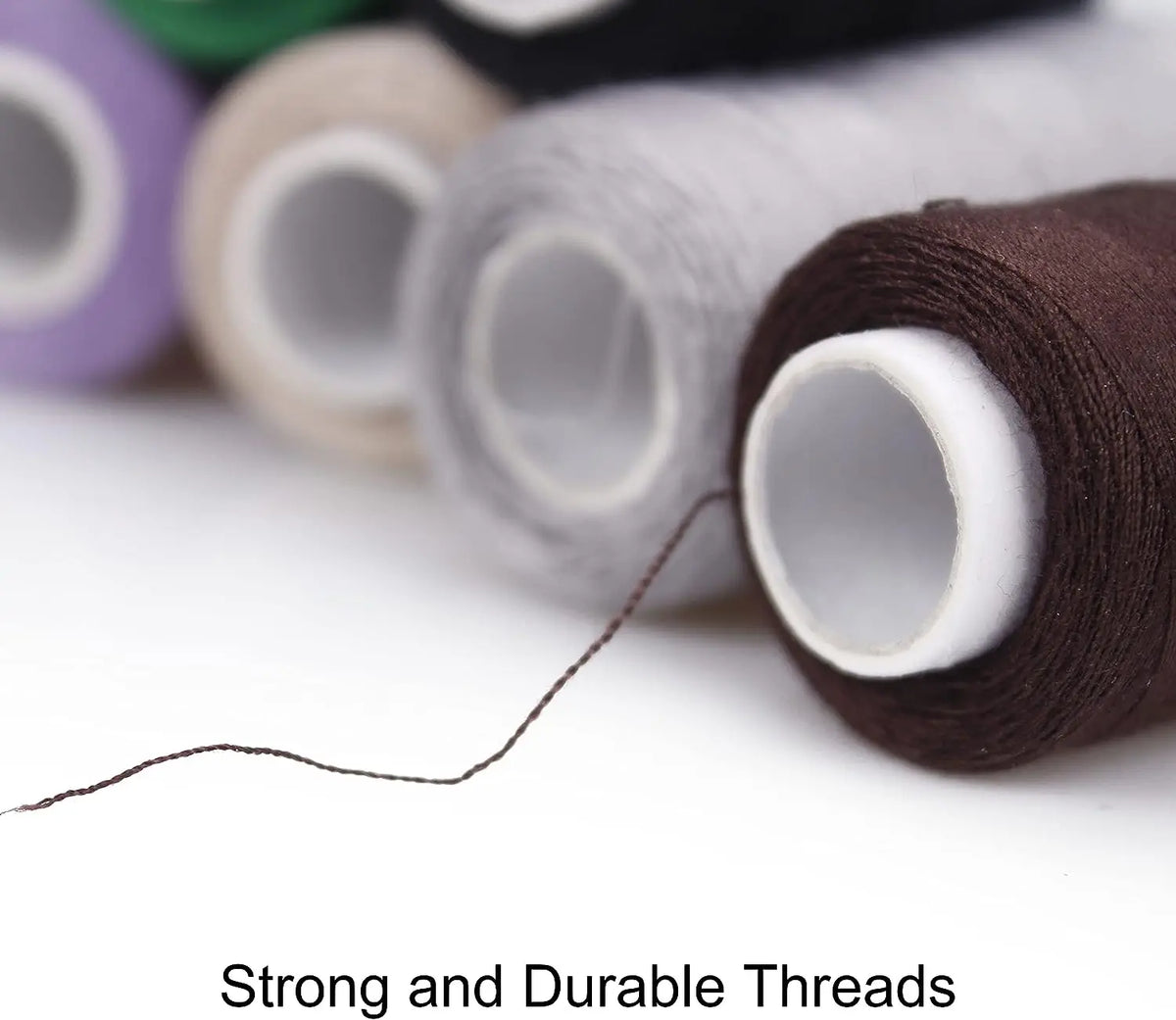 A close-up of various colored polyester sewing threads on spools, with a single strand extending from one spool.