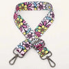 A pink and floral patterned fabric strap for an adjustable crossbody bag.