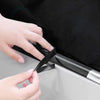 A hand is wrapping a black vinyl wrap strip onto a silver surface.