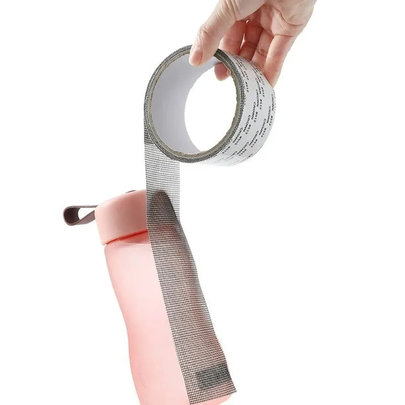 A hand is applying a self-adhesive fiberglass screen repair patch to a pink object.