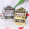A silver and gold mini fruit slot machine keychain fidget toy with bars and a good luck sign.