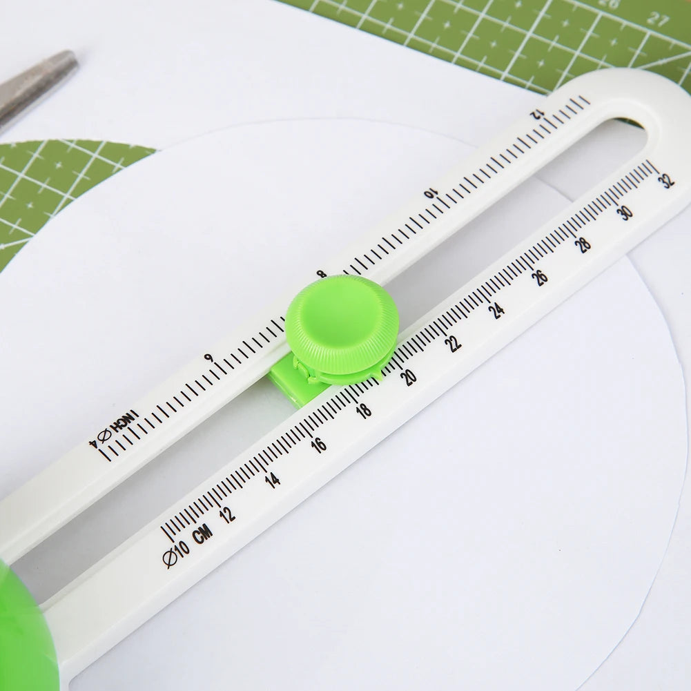 A white adjustable ruler or measuring tool is shown with a green circular component, placed on a white surface.