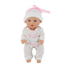 A baby doll wearing a white jumpsuit outfit with pink accents and a pink bow.