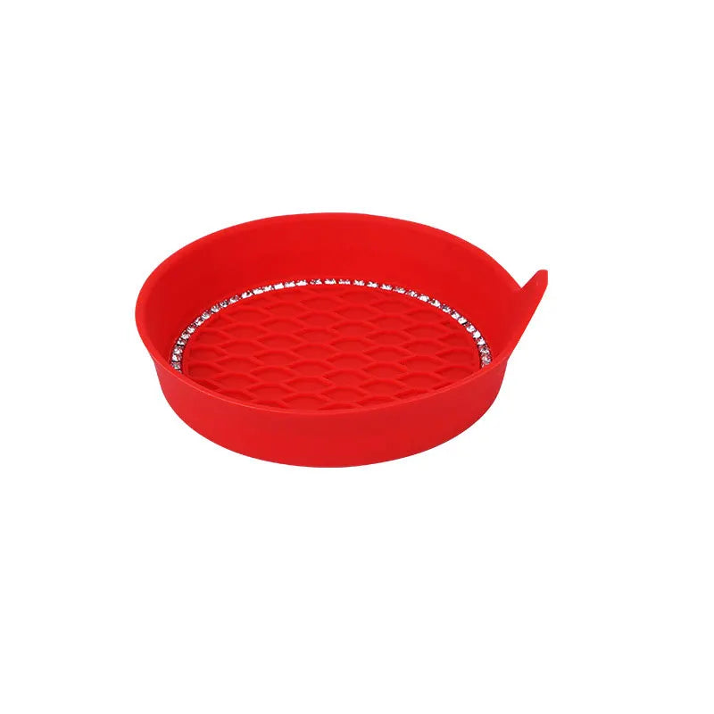 A red silicone cup holder coaster with a textured surface and rhinestone trim.