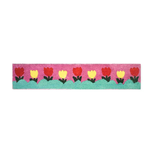 Rechteckige Matte mit einer Reihe bunter, gepuderter Cartoon-Blumen auf rosa Hintergrund.
