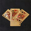 A stack of gold playing cards showing the Jack and King of Clubs against a dark background.