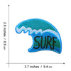 A teal and blue embroidered patch shaped like a sea wave with the word SURF on it.