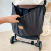 A hand is opening a black bear-themed stroller organizer with a large capacity.