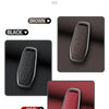 Three color options of a premium zinc alloy leather car key case cover are displayed: brown, black, and red.