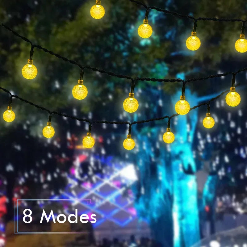 String lights with yellow crystal globes hanging against a dark, blurred background.