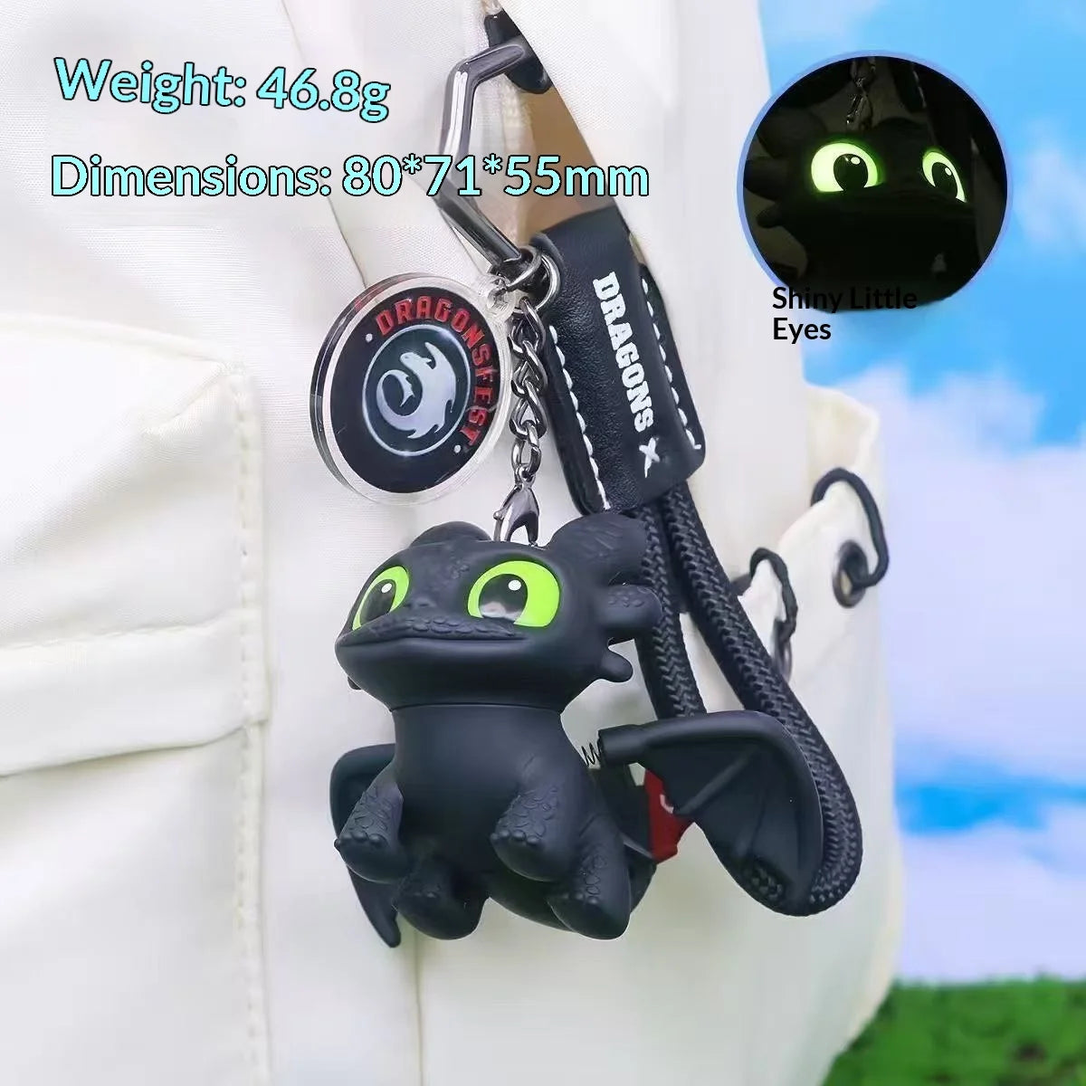 A black Toothless dragon ornament with movable wings attached to a keychain on a white shirt.