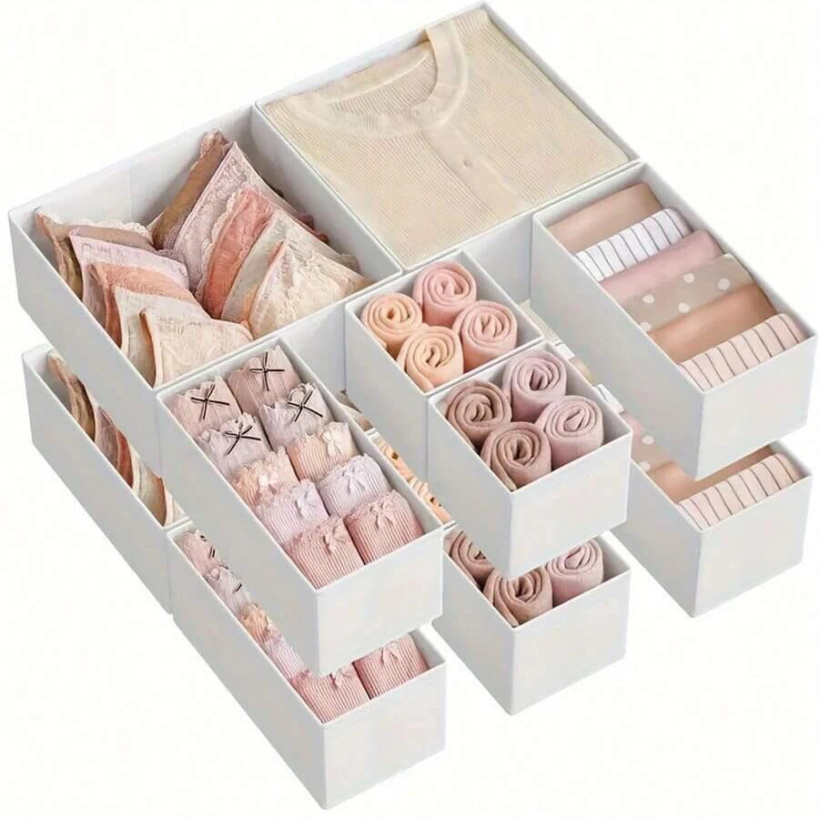 White foldable drawer organizer boxes containing various shades of pink and nude colored underwear, bras, and socks.