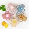 A collection of five silicone training cups with straws and handles in various pastel colors, including pink, blue, and beige