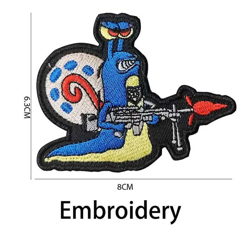 Embroidery of a blue dinosaur with a circular design and a red-tipped tail on a black background.
