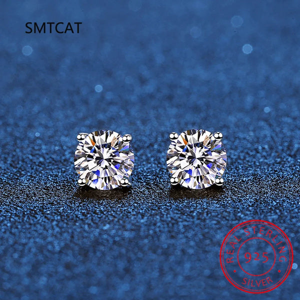 Pair of brilliant clear stud earrings made of moissanite set against a dark blue textured background.