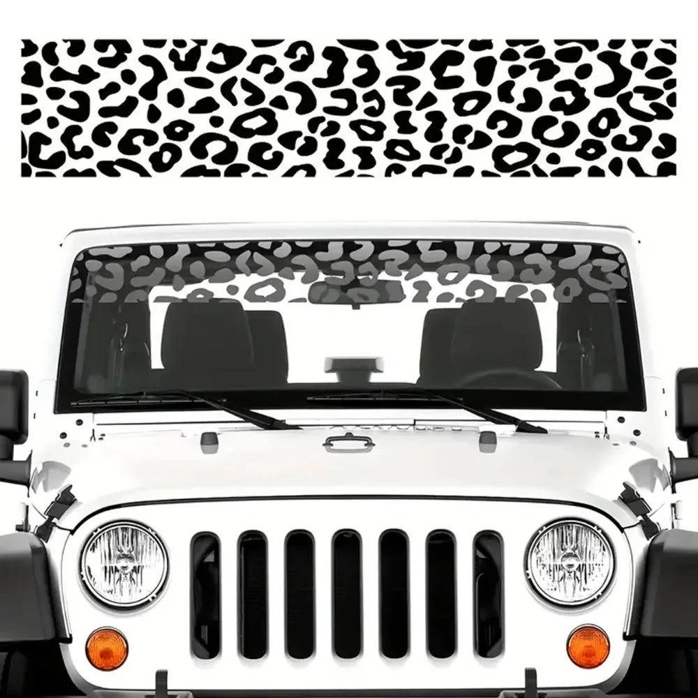 White Jeep front grille with a leopard print sunshade decal strip installed on the windshield.