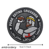 Black embroidered patch featuring a stylized figure with a beard and helmet, surrounded by text.