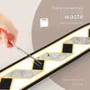 A hand uses a silver craft knife to cut a self-adhesive PVC wall trim featuring a geometric pattern.