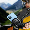 A person wearing a yellow jacket and helmet is using a quick-release motorcycle phone mount to attach a smartphone to their b