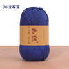 A skein of dark blue cotton blend crochet yarn is displayed on a wooden surface.