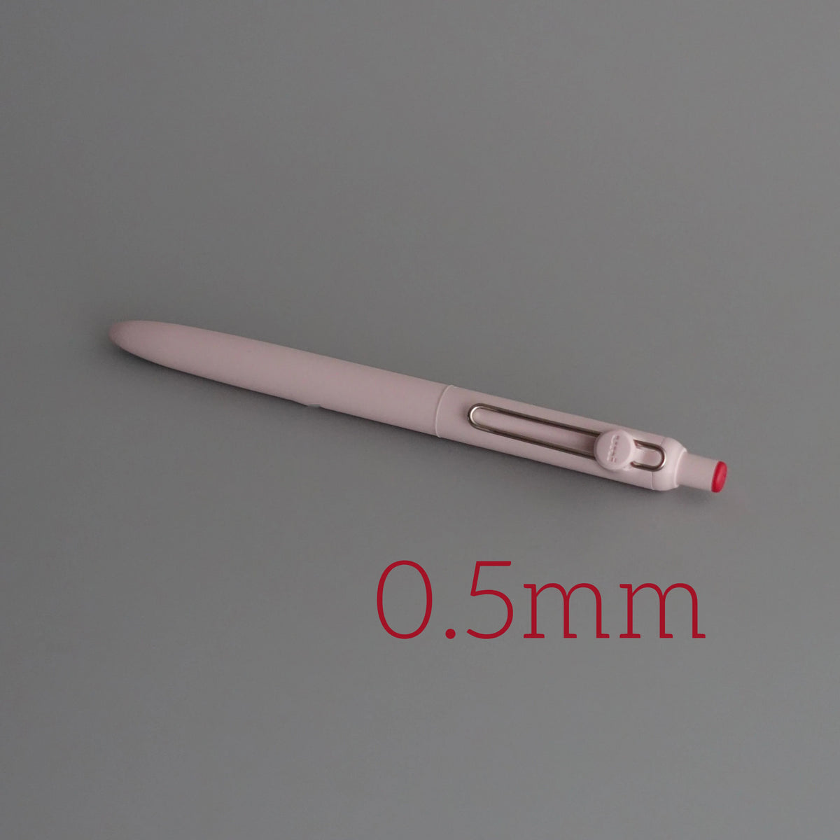 A close-up view of a light pink Uni ZENTO Quick-Dry Gel Pen with a 0.5mm tip.