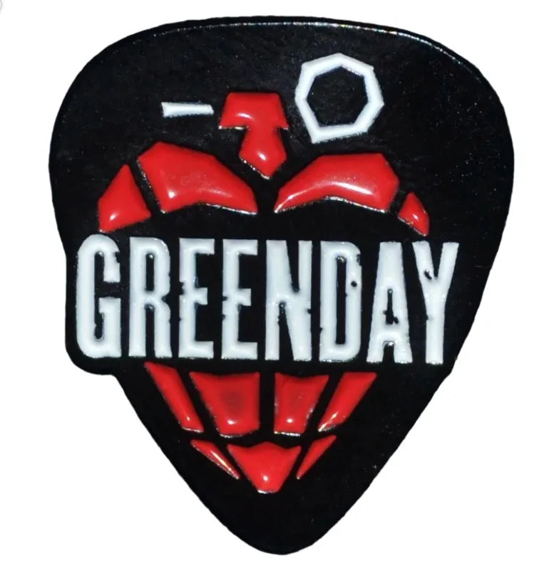 A black pin featuring a red pineapple design and the name GREENDAY in white text.