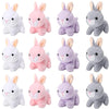 A collection of twelve soft plush bunny toys in various shades of white, pink, lavender, and gray.