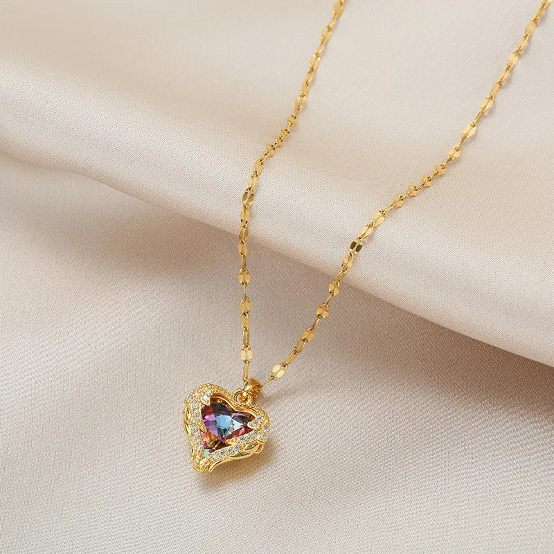 Collier en chaîne doré avec pendentif en forme de cœur et cristaux colorés aux tons océaniques.