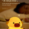 A yellow silicone cow night light with a timer is shown illuminating a sleeping person's face.
