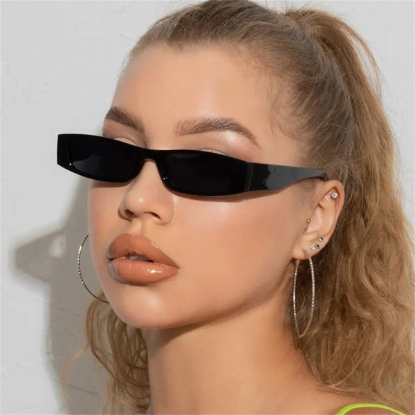 Nahaufnahme einer Modelin mit schwarzen Vintage-Leopard-Rechteckbrillen und goldenen Creolen.