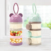 A set of three stackable bear-shaped baby food storage containers in purple, green, and beige.