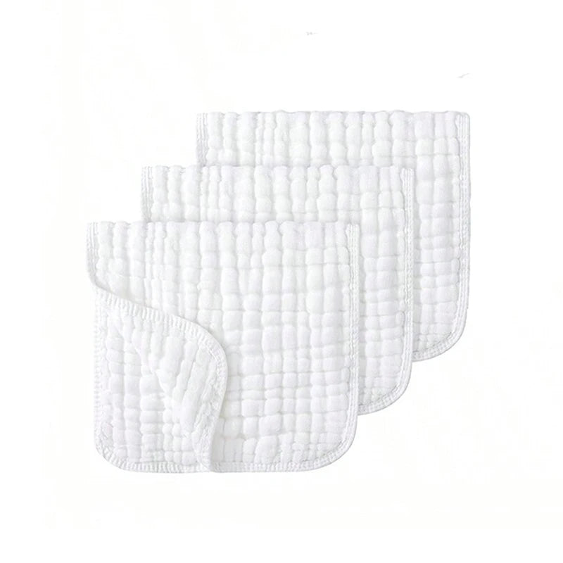 A stack of three white extra soft muslin burp cloths with a textured pattern.