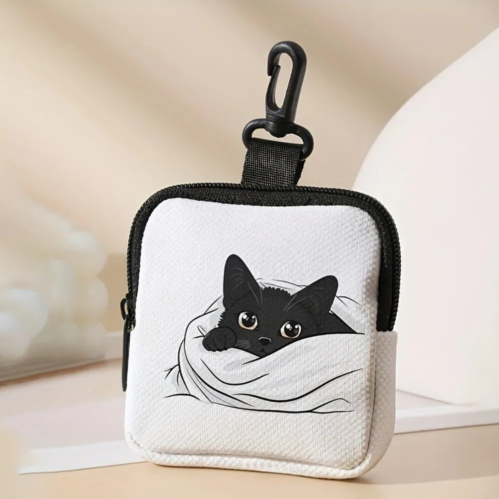 A small black pouch with a cat face print and a black clasp on a light fabric background.