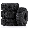 A stack of four black mud terrain rubber tires for RC crawlers.