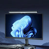 A computer monitor displaying a blue, wavy graphic, illuminated by an attached LED light bar.