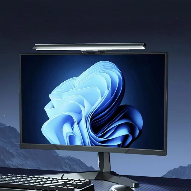 A computer monitor displaying a blue, wavy graphic, illuminated by an attached LED light bar.