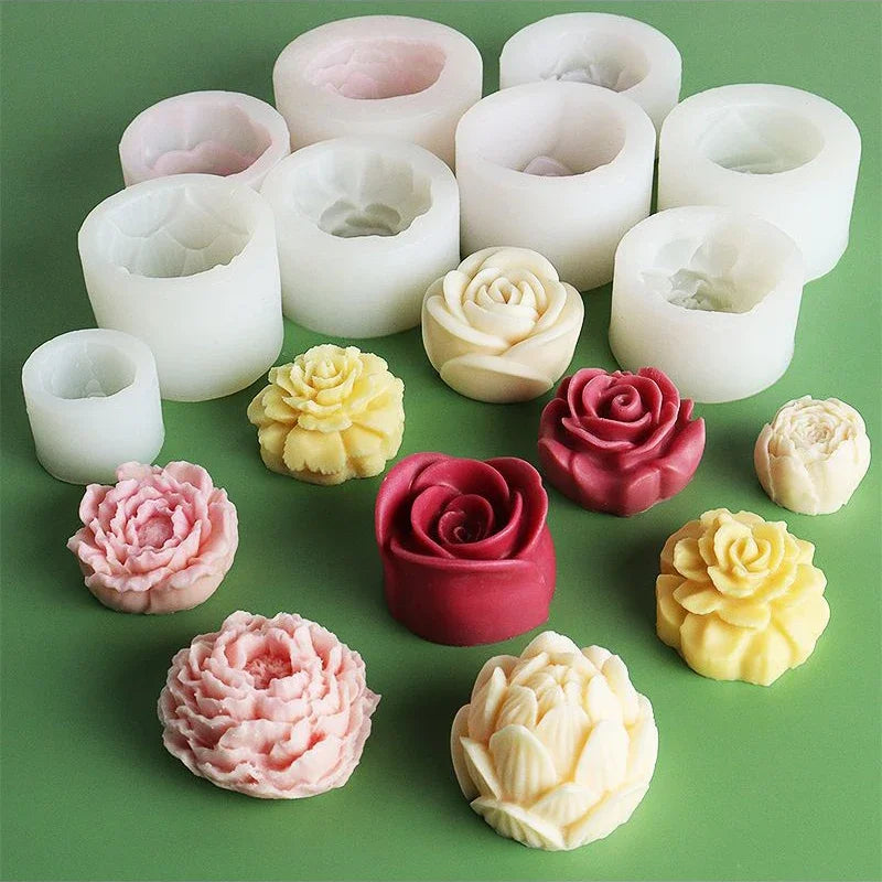 A collection of white and pink silicone molds shaped like roses and peonies for crafting.