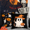 Un juego de fundas decorativas negras con temas de Halloween como calabazas y fantasmas contra un fondo espeluznante.