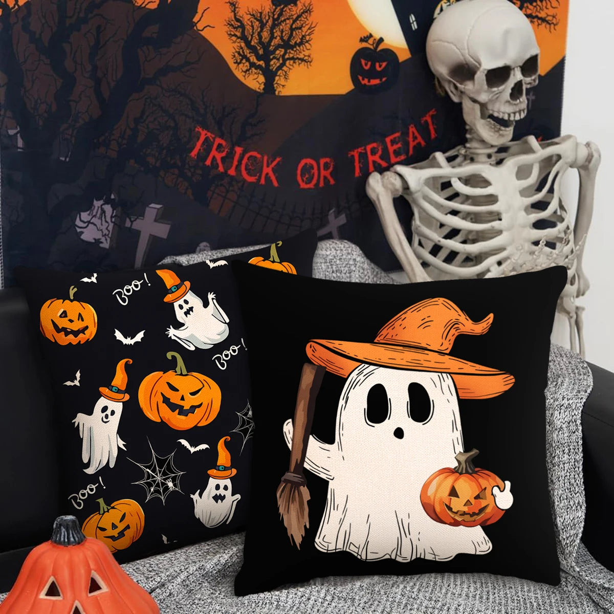Un juego de fundas decorativas negras con temas de Halloween como calabazas y fantasmas contra un fondo espeluznante.