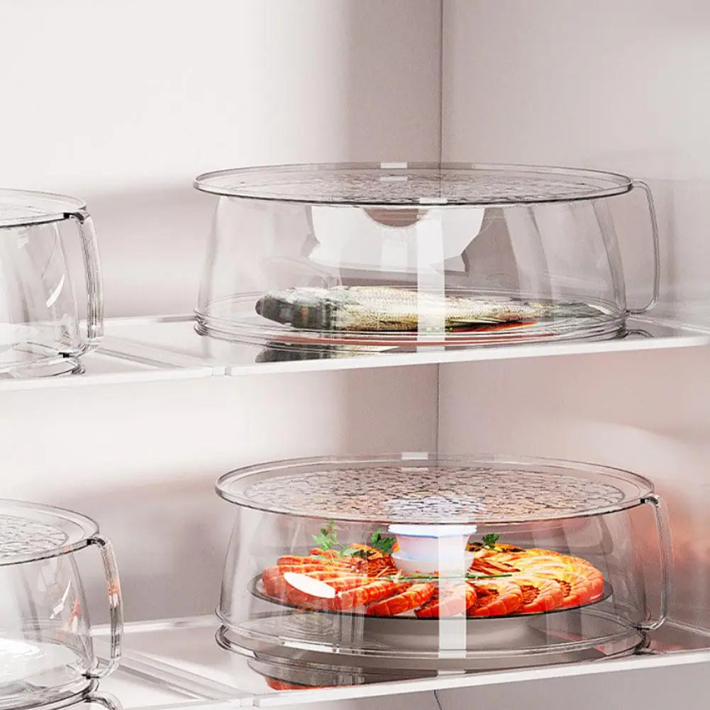 A clear microwave splatter cover with a heat-resistant handle sitting on a shelf.