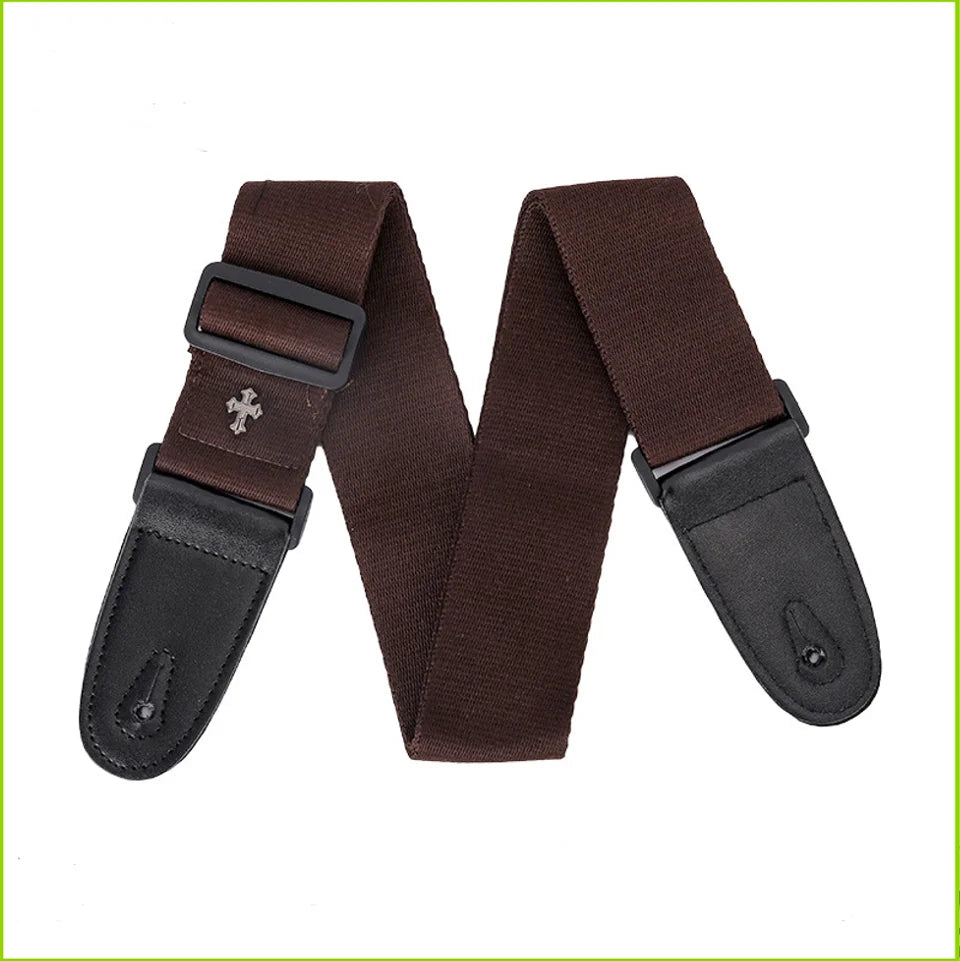 A dark brown guitar strap featuring a vintage cross pattern and a leather pick pocket.