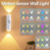 A white motion sensor wall light with multiple colored LED patterns illuminating a wall.
