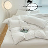 A white duvet cover set with pillows on a bed, showing the interior without the quilt and pillow core.