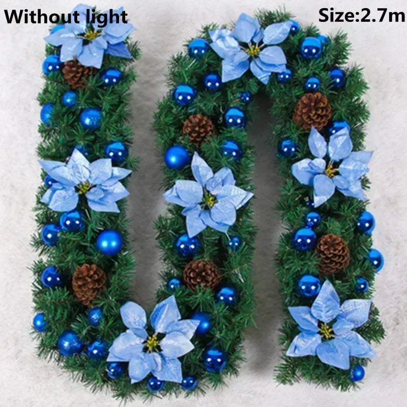 A green artificial Christmas garland shaped like the letter U decorated with blue flowers and blue berries without light.