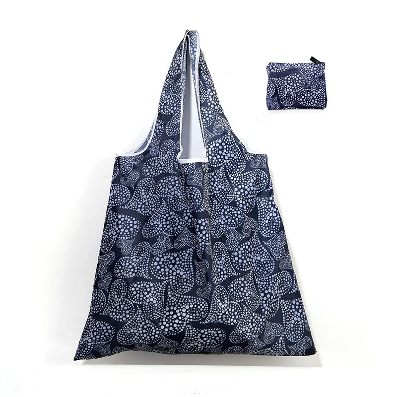 A navy blue patterned reusable shopping tote bag and a matching small carry pouch.