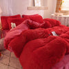 A vibrant red plush mink velvet duvet cover set with sheets displayed on a bed.