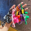 A hand holds a collection of colorful gym-inspired fitness keychains with various charms and clasps.