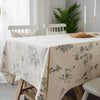 A light beige cotton-linen tablecloth featuring a rustic fern print on a wooden table.